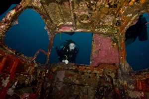 Diver entering the front window of a four seater plane wreck, Philippines, Southeast Asia, Asia Diver entering the front window of a four seater plane wreck, Philippines, Southeast Asia, Asia