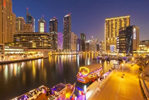Dubai Marina skyline and tourist boats at night, Dubai City, United Arab Emirates Dubai Marina skyline and tourist boats at night, Dubai City, United Arab Emirates