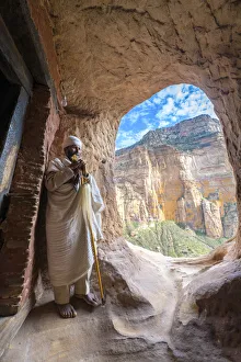 Ethiopian Orthodox priest holding the hand cross at entrance of Abuna Yemata Guh church Ethiopian Orthodox priest holding the hand cross at entrance of Abuna Yemata Guh church