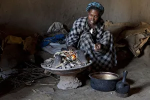 Ethiopian woman setting fire to boil the water for coffee for traditional ceremony Ethiopian woman setting fire to boil the water for coffee for traditional ceremony