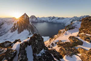 First light of sunrise on Mount Segla and Mefjorden framed by the frozen sea seen from peak Hesten First light of sunrise on Mount Segla and Mefjorden framed by the frozen sea seen from peak Hesten