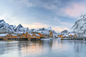 Fishermen's wood cabins covered with snow at sunset in the tiny village of Sakrisoy, Reine, Nordland Fishermen's wood cabins covered with snow at sunset in the tiny village of Sakrisoy, Reine, Nordland