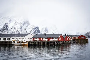 Foggy sky over snowcapped mountains and traditional Rorbu cabins by the sea, Hamnoy, Nordland county, Lofoten Islands Foggy sky over snowcapped mountains and traditional Rorbu cabins by the sea, Hamnoy, Nordland county, Lofoten Islands