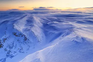 Fresh snow shaped by the cold Arctic wind blowing over mountains at dawn, Tana Fresh snow shaped by the cold Arctic wind blowing over mountains at dawn, Tana