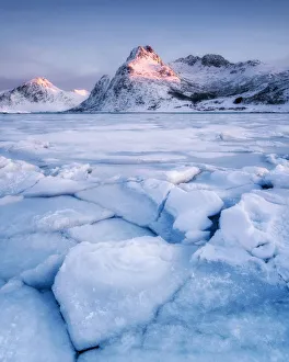 Frozen lake in front of mountain in the early morning light, Lofoten Islands, Nordland Frozen lake in front of mountain in the early morning light, Lofoten Islands, Nordland