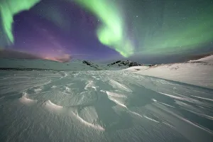 Frozen snow lit by green lights of the Northern Lights (Aurora Borealis Frozen snow lit by green lights of the Northern Lights (Aurora Borealis