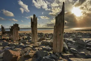 Sunset Over The Ocean UK Prints: Groynes on the beach at Crow Point during sunset in Devon, Great Britain