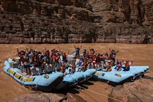 Happy tourists on two rafts celebrating, in the beautiful scenery of the Colorado River Happy tourists on two rafts celebrating, in the beautiful scenery of the Colorado River