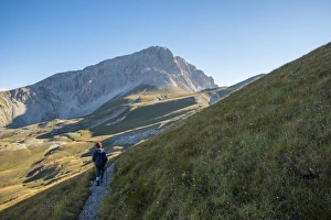 Hiker on the path to the summit of peak Corno Grande, Gran Sasso e Monti della Laga National Park Hiker on the path to the summit of peak Corno Grande, Gran Sasso e Monti della Laga National Park