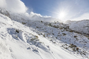 Hikers proceed in the snowy valley of Alpe Fora, Malenco Valley, Province of Sondrio Hikers proceed in the snowy valley of Alpe Fora, Malenco Valley, Province of Sondrio