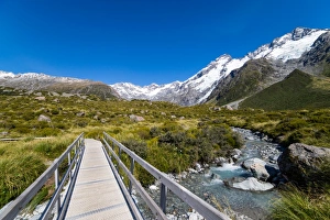 A hiking trail crosses wooden bridge over a creak high up in the mountains, South Island A hiking trail crosses wooden bridge over a creak high up in the mountains, South Island