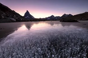 Ice bubbles in the Riffelsee Lake during sunset. Zermatt, Mattertal, Canton of Valais Ice bubbles in the Riffelsee Lake during sunset. Zermatt, Mattertal, Canton of Valais