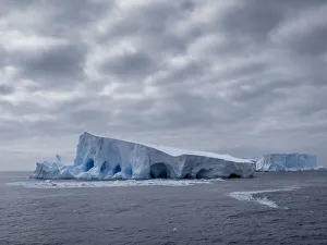 A large iceberg with holes and arches formed in it near Coronation Island, South Orkneys, Antarctica, Polar Regions A large iceberg with holes and arches formed in it near Coronation Island, South Orkneys, Antarctica, Polar Regions