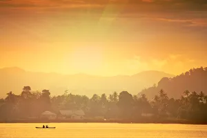 A local fisherman in a traditional canoe in front of the ridges of the Banda islands A local fisherman in a traditional canoe in front of the ridges of the Banda islands
