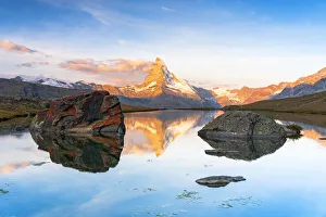 Matterhorn lit by sunrise reflected in the calm water of lake Stellisee, Zermatt Matterhorn lit by sunrise reflected in the calm water of lake Stellisee, Zermatt