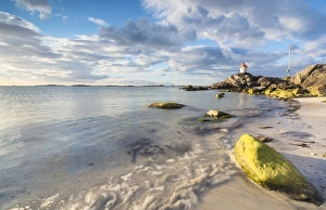 Midnight sun lights up cliffs and sandy beach surrounded by turquoise sea, Eggum Midnight sun lights up cliffs and sandy beach surrounded by turquoise sea, Eggum