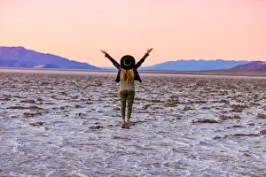 Model posing for the camera at sunset over the salt flats of the Mesquite Dunes Model posing for the camera at sunset over the salt flats of the Mesquite Dunes