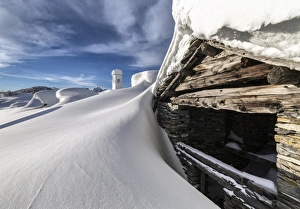 A mountain hut emerging from thick snow after a heavy snowfall in the Alpe Scima, Valchiavenna, Lombardy, Italy, Europe A mountain hut emerging from thick snow after a heavy snowfall in the Alpe Scima, Valchiavenna, Lombardy, Italy, Europe