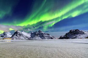 Northern Lights (aurora borealis) illuminate the sky and the snowy peaks, Flakstad Northern Lights (aurora borealis) illuminate the sky and the snowy peaks, Flakstad