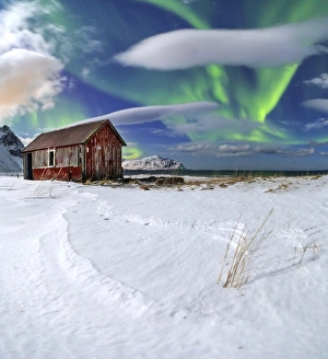 Northern Lights (aurora borealis) over an abandoned log cabin surrounded by snow Northern Lights (aurora borealis) over an abandoned log cabin surrounded by snow