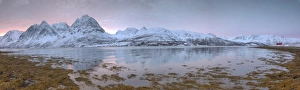 Panorama of pink sky at dawn on snowy fields and wooden hut surrounded by frozen sea Panorama of pink sky at dawn on snowy fields and wooden hut surrounded by frozen sea