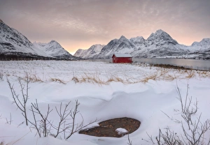 Panorama of pink sky at dawn on the wooden hut surrounded by frozen sea and snowy peaks Panorama of pink sky at dawn on the wooden hut surrounded by frozen sea and snowy peaks