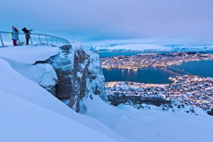 People admire the city of Tromso at dusk from the mountain top reached by the Fjellheisen cable car People admire the city of Tromso at dusk from the mountain top reached by the Fjellheisen cable car