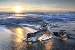Pieces of glacier ice washed up on black volcanic sand beach at sunrise, near Jokulsarlon Pieces of glacier ice washed up on black volcanic sand beach at sunrise, near Jokulsarlon