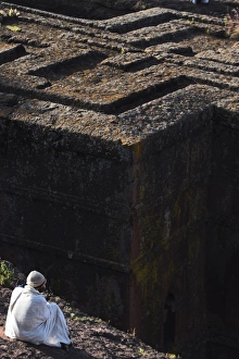 Pilgrim in traditional white shawl at the rock hewn monolithic church of Bet Giyorgis (St Pilgrim in traditional white shawl at the rock hewn monolithic church of Bet Giyorgis (St