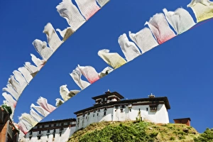 Buddhism In The Himalayas Prints: Prayer flags below Wangdue Phodrang Dzong, founded by the Zhabdrung in 1638, Bhutan, Asia