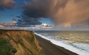 British Seaside Scene Prints: A rain cloud approaches the cliffs at Weybourne, Norfolk, England
