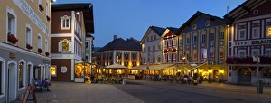 Restaurants in Market Square illuminated at dusk, Mondsee, Mondsee Lake Restaurants in Market Square illuminated at dusk, Mondsee, Mondsee Lake