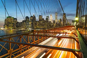 Rush hour traffic at night on Brooklyn Bridge and Manhattan skyline beyond, New York City Rush hour traffic at night on Brooklyn Bridge and Manhattan skyline beyond, New York City