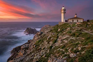 Sea landscape view of Cape Tourinan Lighthouse at sunset with pink clouds, Galicia, Spain Sea landscape view of Cape Tourinan Lighthouse at sunset with pink clouds, Galicia, Spain