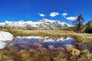 Graubunden Canton Tourism Prints: Snowcapped mountains reflected in a pristine lake in springtime