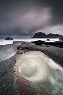 Storm clouds over The Eye rock formation washed by waves, Uttakleiv, Leknes, Vestvagoy, Nordland, Lofoten Islands Storm clouds over The Eye rock formation washed by waves, Uttakleiv, Leknes, Vestvagoy, Nordland, Lofoten Islands