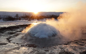 Strokkur Geysir erupting at sunrise during winter, geothermal area beside the Hvita River Strokkur Geysir erupting at sunrise during winter, geothermal area beside the Hvita River