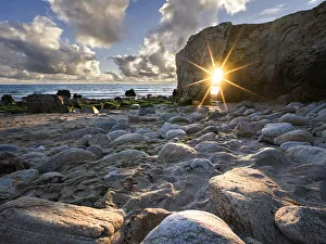 Sun burst aligned with the natural arch of Port Blanc, Quiberon, Brittany, France, Europe Sun burst aligned with the natural arch of Port Blanc, Quiberon, Brittany, France, Europe