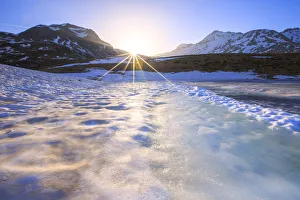 Sunburst on Lake Andossi during thaw, Chiavenna Valley, Spluga Valley, Sondrio province Sunburst on Lake Andossi during thaw, Chiavenna Valley, Spluga Valley, Sondrio province