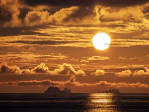 Sunset on a large iceberg at sea towards Peter I Island, Bellingshausen Sea, Antarctica, Polar Regions Sunset on a large iceberg at sea towards Peter I Island, Bellingshausen Sea, Antarctica, Polar Regions