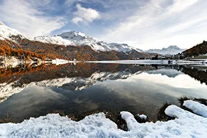 Sunset over Piz Da La Margna and Piz Corvatsch peaks reflected in lake Champfer during a Sunset over Piz Da La Margna and Piz Corvatsch peaks reflected in lake Champfer during a