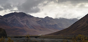 Tourist bus driving among mountains in the Denali National Park, Alaska, United States of America Tourist bus driving among mountains in the Denali National Park, Alaska, United States of America