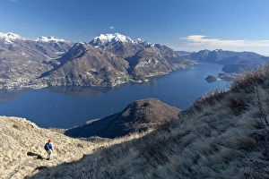 A tourist contemplating the landscape of Lake Como from a path in the High Route of Monti A tourist contemplating the landscape of Lake Como from a path in the High Route of Monti
