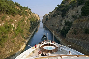 Tourists on the bow of a ship being pulled by tug through Tourists on the bow of a ship being pulled by tug through