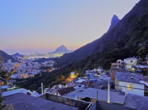 Twilight view of the Favela Santa Marta with Corcovado and the Christ statue behind Twilight view of the Favela Santa Marta with Corcovado and the Christ statue behind
