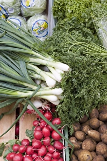 Vegetables including spring onions, potatoes and radishes on market stall Vegetables including spring onions, potatoes and radishes on market stall
