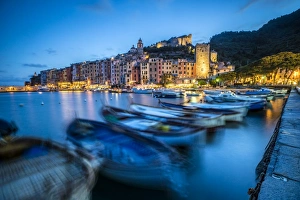 View of blue sea and boats surrounding the colorful village at dusk, Portovenere View of blue sea and boats surrounding the colorful village at dusk, Portovenere