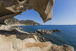 View of the blue sea from a natural sea cave of rocks shaped by wind, Punta Molentis View of the blue sea from a natural sea cave of rocks shaped by wind, Punta Molentis