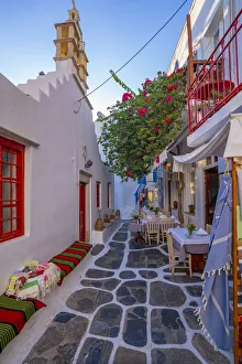 View of cafe in colourful narrow cobbled street, Mykonos Town, Mykonos, Cyclades Islands View of cafe in colourful narrow cobbled street, Mykonos Town, Mykonos, Cyclades Islands