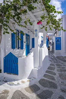 View of girl walking through whitewashed narrow street, Mykonos Town, Mykonos View of girl walking through whitewashed narrow street, Mykonos Town, Mykonos